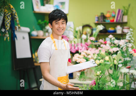 Portrait of smiling flower shop owner working. Small business.