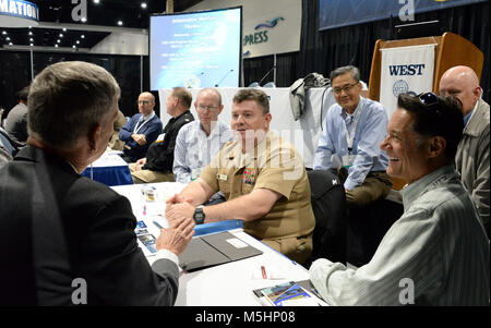 SAN DIEGO (Feb. 7, 2018) – Capt. Andrew Gibbons, program manager of the Communications and GPS Navigation Program Office (PMW/A 170), meets with members of industry during a “Meet the Program Managers” event at WEST 2018.  This event provides an opportunity for leaders from the Program Executive Office Command, Control, Communications, Computers and Intelligence (PEO C4I), PEO Space Systems, PEO Enterprise Information Systems (EIS) and PEO Tactical Aircraft Programs to facilitate numerous conversations with local, national and international industry leads. WEST 2018 is the premier naval confer Stock Photo