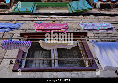 Typical Dalmatian/ Mediterranean scene of Colorful clothes laundry drying outdoor under sun and open sky in line Stock Photo