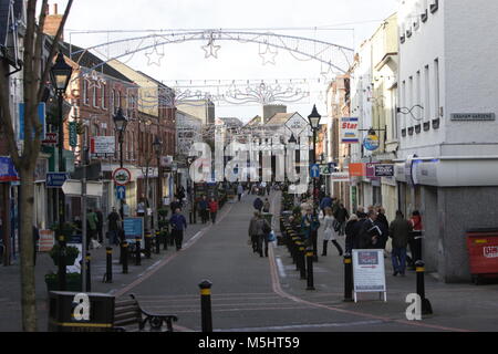 Lisburn, Northern Ireland. Lisburn (/'l?z.b?rn/ or /'l?s.b?rn/; meaning 'fort of the stream', probably from Irish lios, meaning 'fort', and Scots burn, meaning 'stream') is a city in Northern Ireland. It is 8 mi (13 km) southwest of Belfast city centre, on the River Lagan, which forms the boundary between County Antrim and County Down. Lisburn is part of the Belfast Metropolitan Area. It had a population of over 71,469 people in the 2011 Census. Formerly a borough, Lisburn was granted city status in 2002 as part of Queen Elizabeth II's Golden jubilee celebrations. It is the third-largest city  Stock Photo