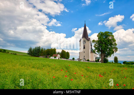 Lonely church in the poppy field before storm Stock Photo