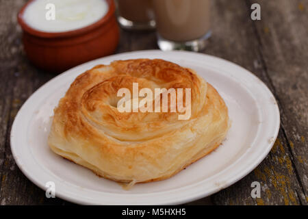 Traditional Bulgarian pastry Banitsa on a rustic table with Greek yogurt and juice Stock Photo