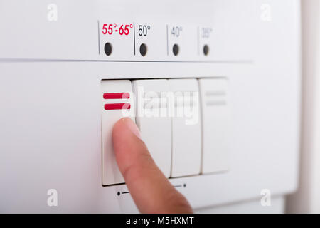 Close-up Of Person Hands Pressing Button Of Dishwasher In Kitchen Stock Photo