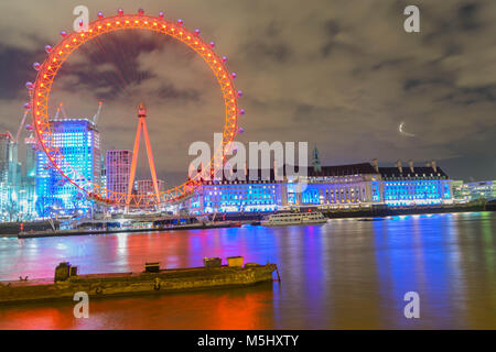 London, United Kingdom, February 17, 2018: UK skyline in the evening. Ilumination of the London Eye and the buildings next to River Thames Stock Photo