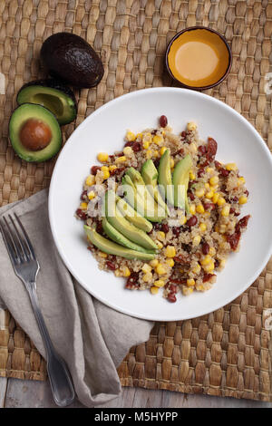 Quinoa and vegetables salad with avocado on a rustic table Stock Photo