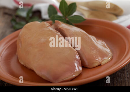 Raw foie gras, the fatened goose liver on a rustic table Stock Photo