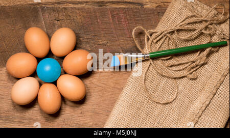 Pattern of painted eggs on wooden table for Easter with paintbrush Stock Photo