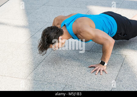 Athlete exercising push-ups in the city Stock Photo