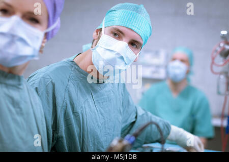 Neurosurgeons in scrubs during an operation Stock Photo