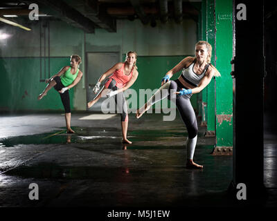 Three women having a workout in a hall Stock Photo