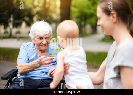 Portrait of happy senior woman with daughter and granddaughter in a park Stock Photo