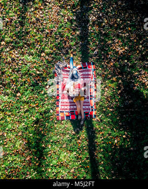 Two pretty women lying on the floor in an autumnal forest. Top view Stock Photo