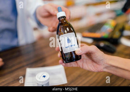 Pharmacist giving medicine to customer in pharmacy Stock Photo