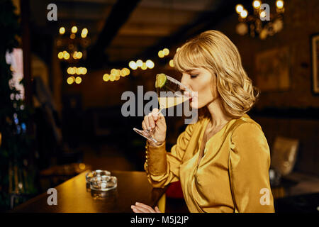 Elegant woman drinking cocktail in a bar Stock Photo