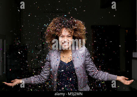 Confetti falling on happy woman Stock Photo