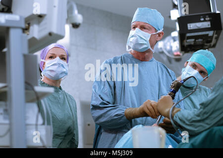 Team of neurosurgeons in scrubs during an operation Stock Photo