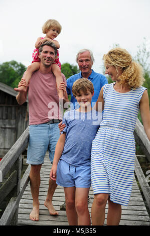 Happy family walking together on boardwalk in summer Stock Photo