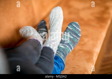 Feet of couple in love lying on couch Stock Photo