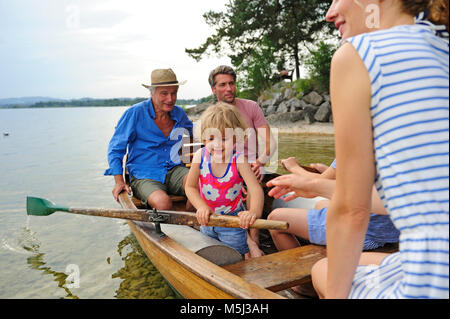 Germany, Bavaria, Murnau, happy little girl with her family in rowing boat at lakeshore Stock Photo