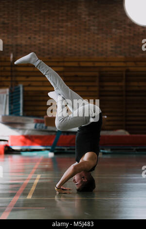 Young man doing a headstand in gym Stock Photo