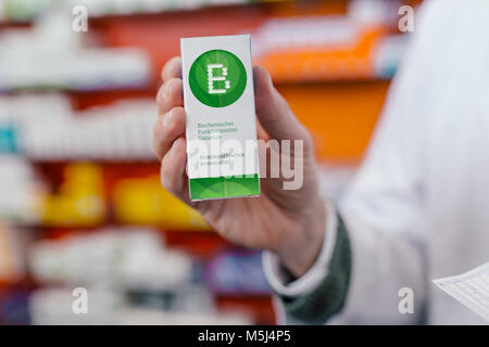Pharmacist holding homeopathic medicine in pharmacy Stock Photo