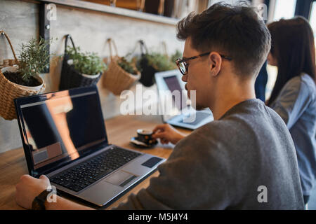 Young man and woman in a cafe using laptops Stock Photo