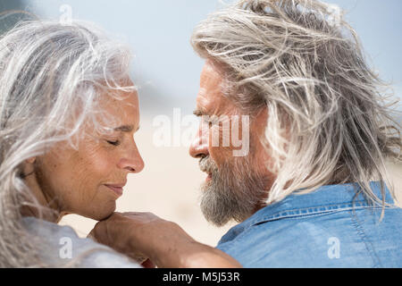 Affectionate senior couple looking into each others eyes in front of the sea Stock Photo