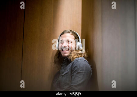 Portrait of laughing man listening music with headphones Stock Photo