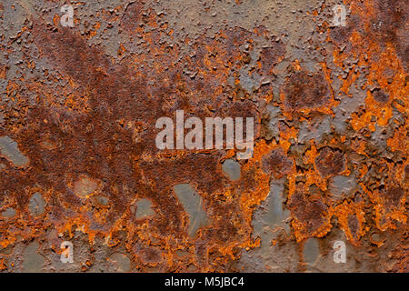 Vivid rust and peeling paint from metal sheet background texture Stock Photo