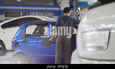 Worker in auto service preparing car for professional diagnostic, close up Stock Photo