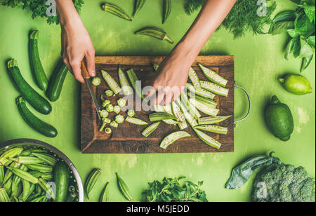 Flat-lay of healthy green vegan cooking ingredients on board Stock Photo