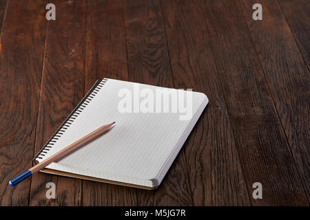 White checked copybook with pencil on pine brown wooden board education concept Stock Photo