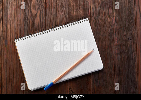 White checked copybook with pencil on pine brown wooden board education concept Stock Photo