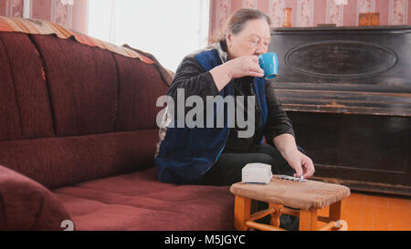 Senior lady - elderly woman at home drinking from a mug - pension life Stock Photo