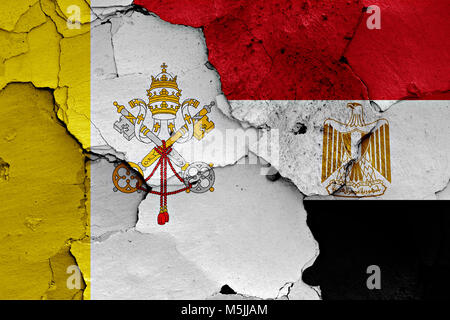 flag of Vatican and Egypt painted on cracked wall Stock Photo