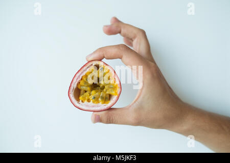 hand of caucasian woman holding juicy passion fruit Stock Photo