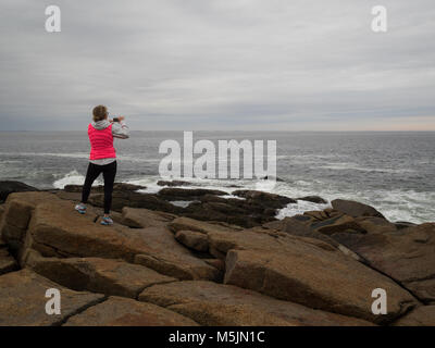 Woman standing on rocks at Halibut Point State Park, Rockport, MA. Stock Photo