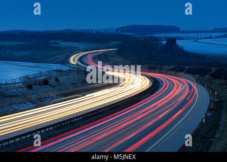 Traces of light on the A9 motorway,curvy road,twilight,winter,long-term exposure,near Schleiz,Thuringia,Germany Stock Photo