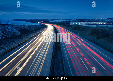 Traces of light on the A9 motorway,curvy road,twilight,winter,long-term exposure,near Schleiz,Thuringia,Germany Stock Photo