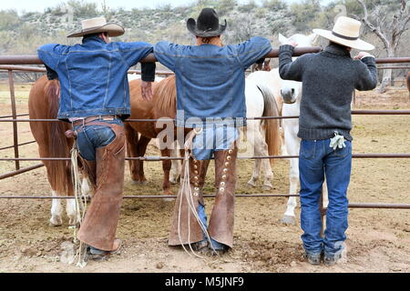 Three cowboys take a break at the corral Stock Photo