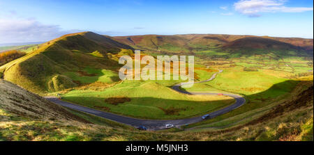 Long and winding rural road of Winnat Pass  leading through green hills in the Peak District, UK Stock Photo