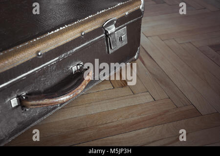 Vintage closed suitcase on the parquet. Selective focus. Stock Photo