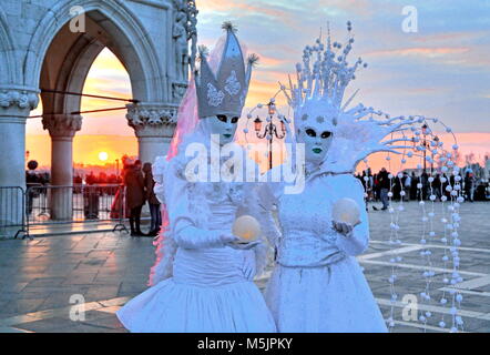 Disguised couple with Venetian masks at sunset,carnival in Venice,Italy Stock Photo