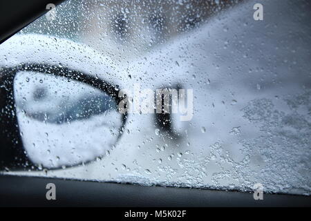 Water drops on car window close-up. Dangerous driving in bad weather conditions. Rainy weather outside car. Stock Photo