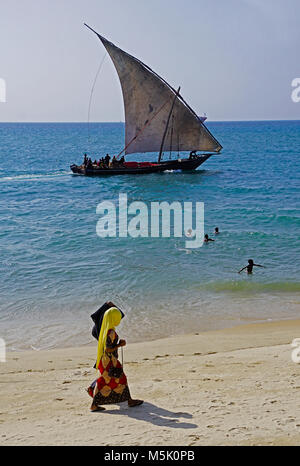 Dhow sailing just off the beach of Stone Town in Zanzibar. Stock Photo