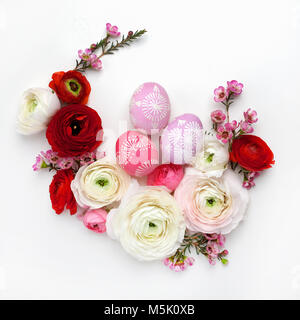 Circle border for easter card or invitation. Wreath with easter chicken eggs and ranunculus flowers. On a white background with place for text. Stock Photo