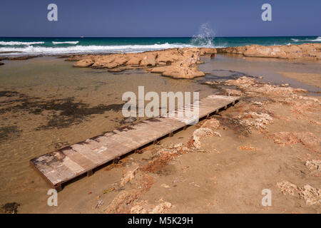 Rocky beach and boardwalk at Malia on the Mediterranean coast of Crete Stock Photo