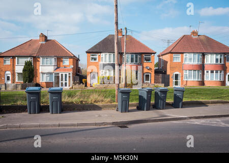 A street of semi detached houses with wheelie bins on the pavement for collection uk Stock Photo