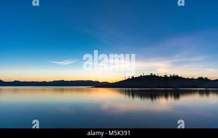 Sunrise at Lake Pleasant in Peoria Arizona. I was out hiking and captured this long exposure of this beautiful mountain casting a shadow over the lake. Stock Photo