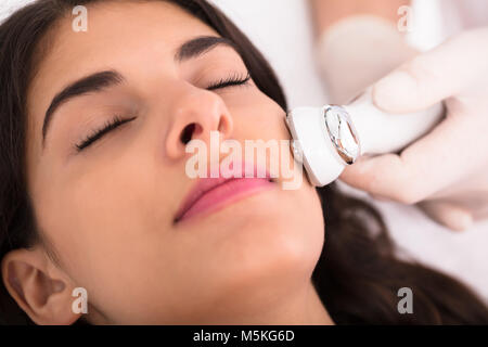Close-up Of A Therapist Giving Needle Free Mesotherapy Treatment On Women's Face Stock Photo